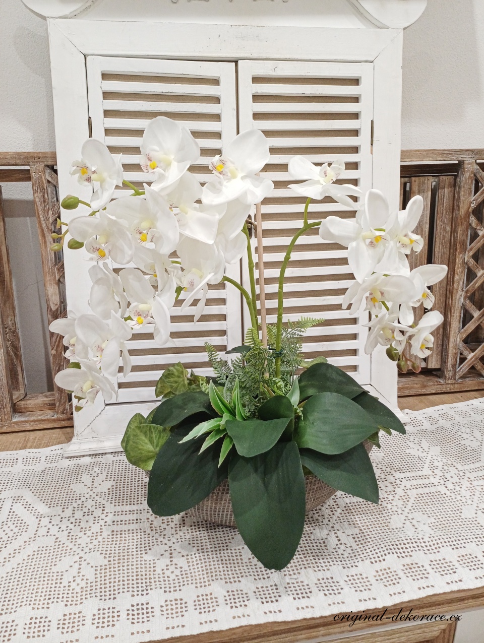 Bílá orchidej v hnědé keramické loďce